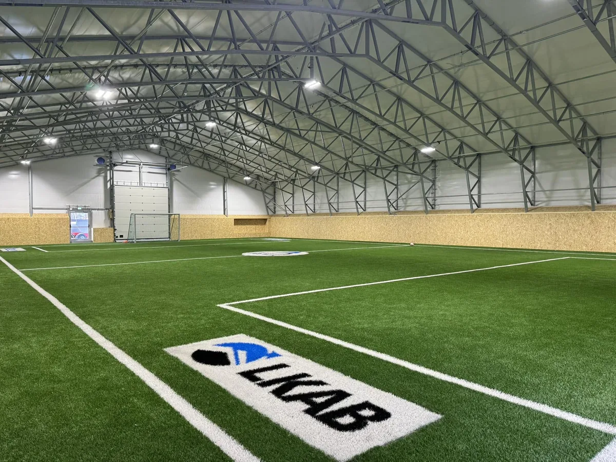 Ferdig kunstgress med sponsorlogo i hallen