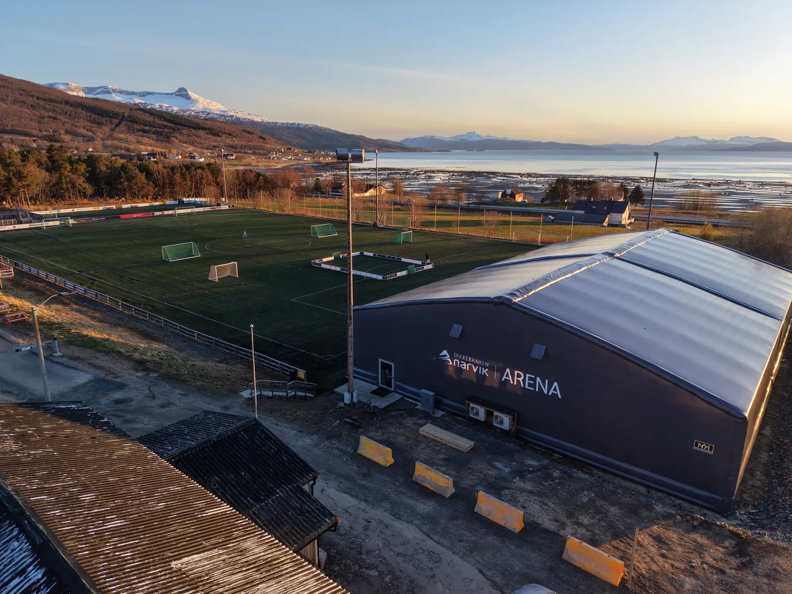 Hallen og banen fra lufta med fjell i det fjerne