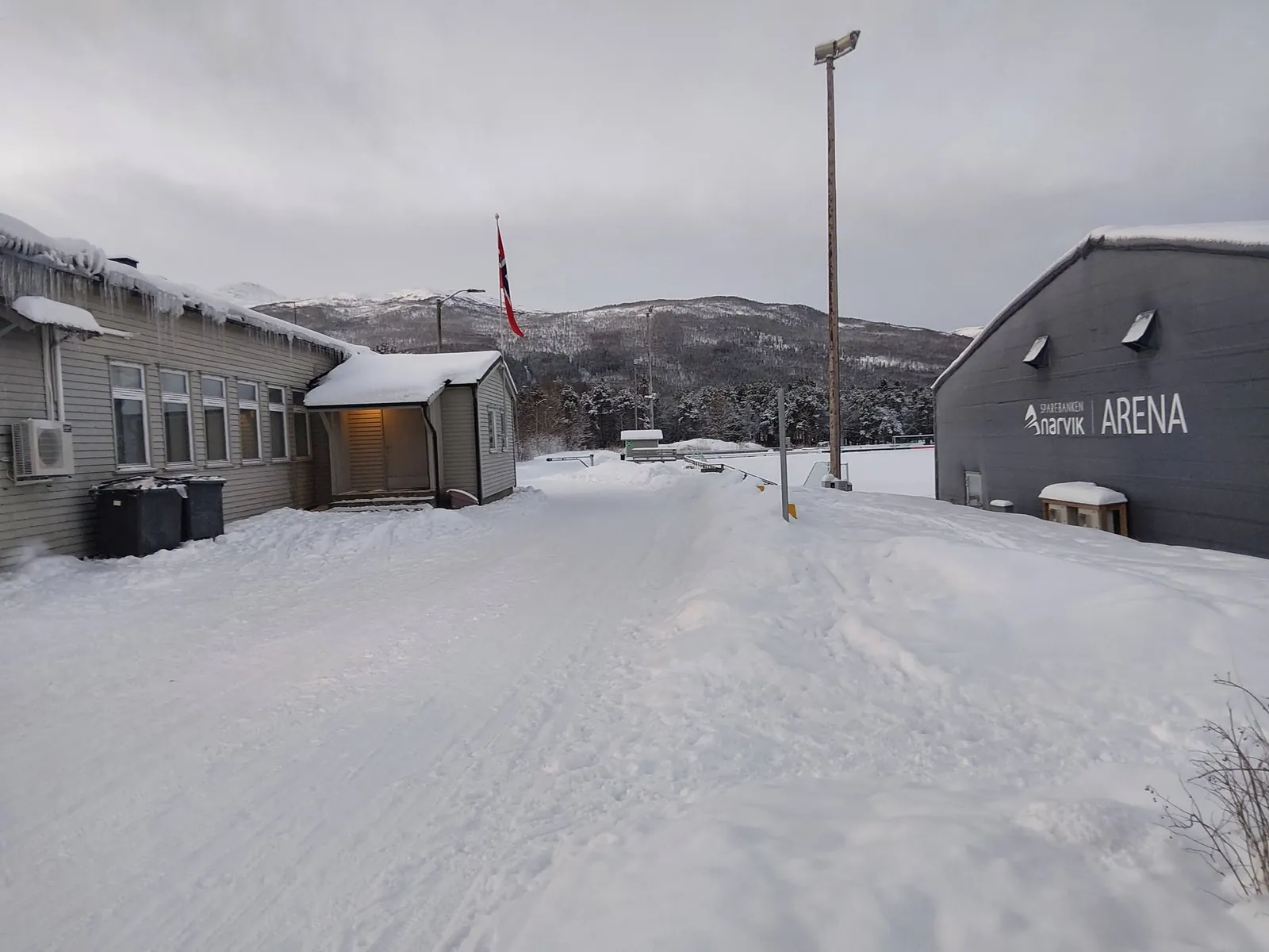 Idrettsheimen vinterstid med hallen i bakgrunnen