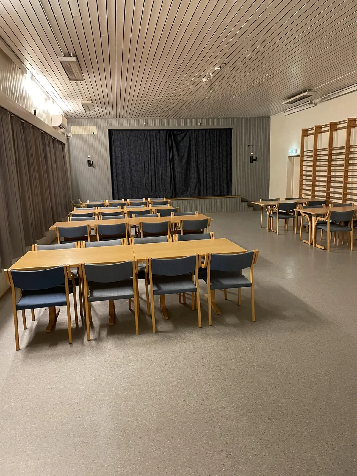 Salen i Idrettsheimen med bord og stoler