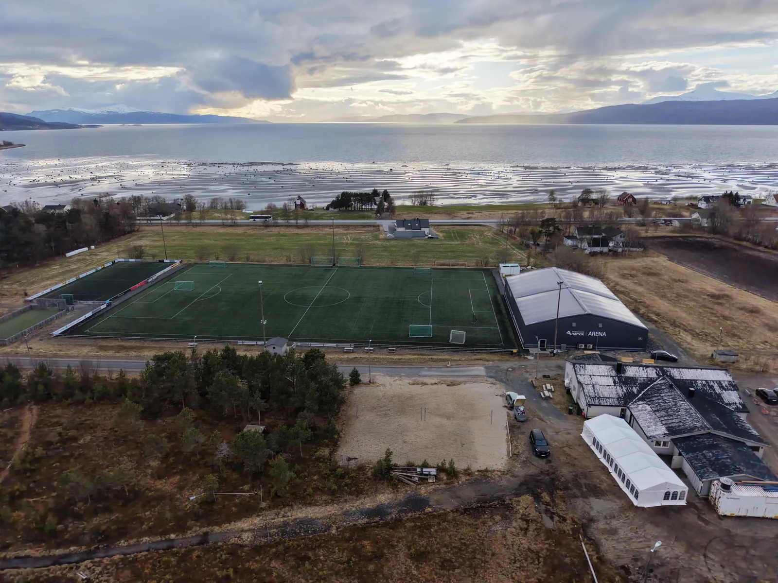 Kunstgressbanen med fjorden og fjellene på andre siden