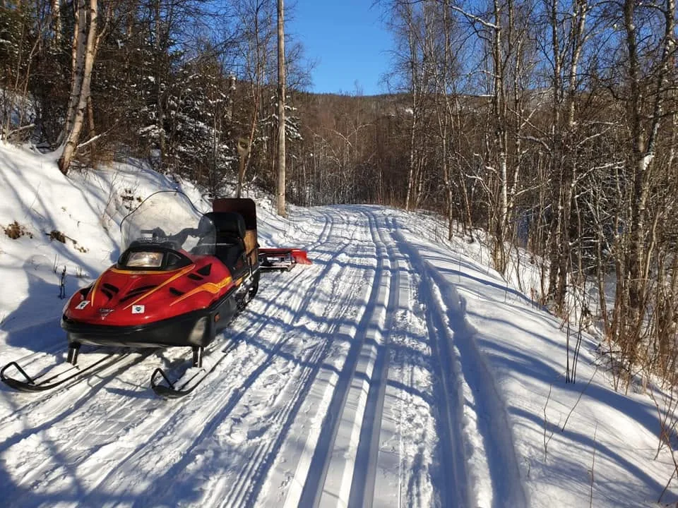 Snøscooter med sporsetter i lysløypa