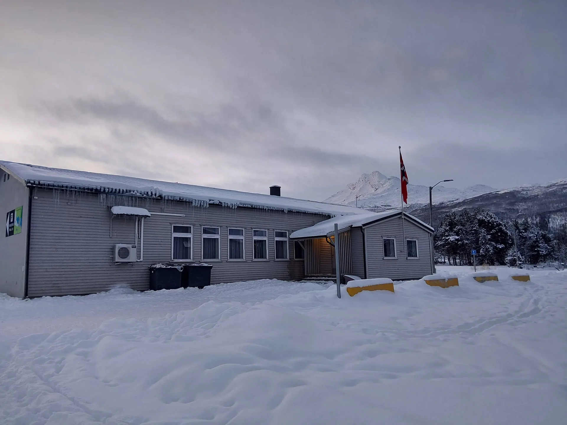 Idrettsheimen i snø med Den sovende dronning bak